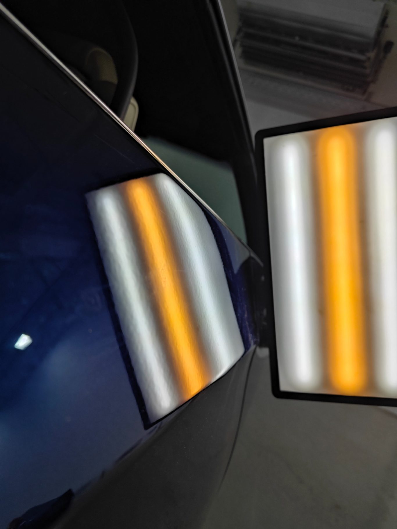 BMW 335i Türe nachher Ein rechteckiges Lichtpaneel spiegelt sich auf einer glänzenden Oberfläche.