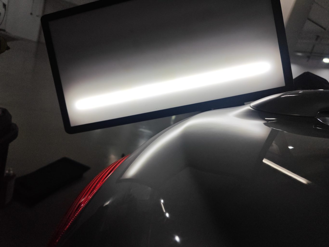 Peugeot 206 CC Heckklappe nachher Graue Oberfläche eines Fahrzeugmodells mit reflektierendem Licht im Hintergrund.