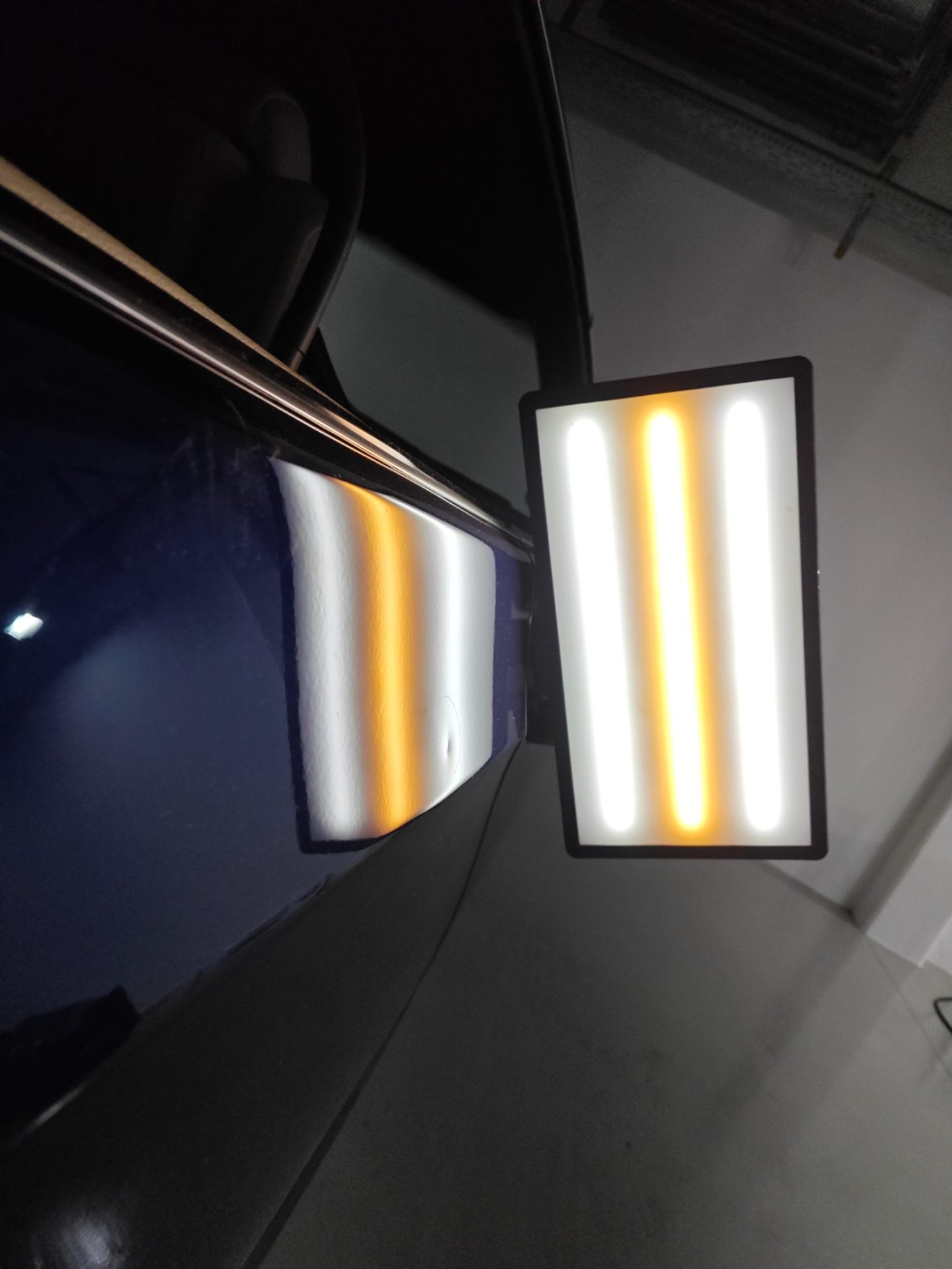 BMW 335i Türe vorher Ein rechteckiges Lichtpaneel spiegelt sich auf einer glänzenden Oberfläche.
