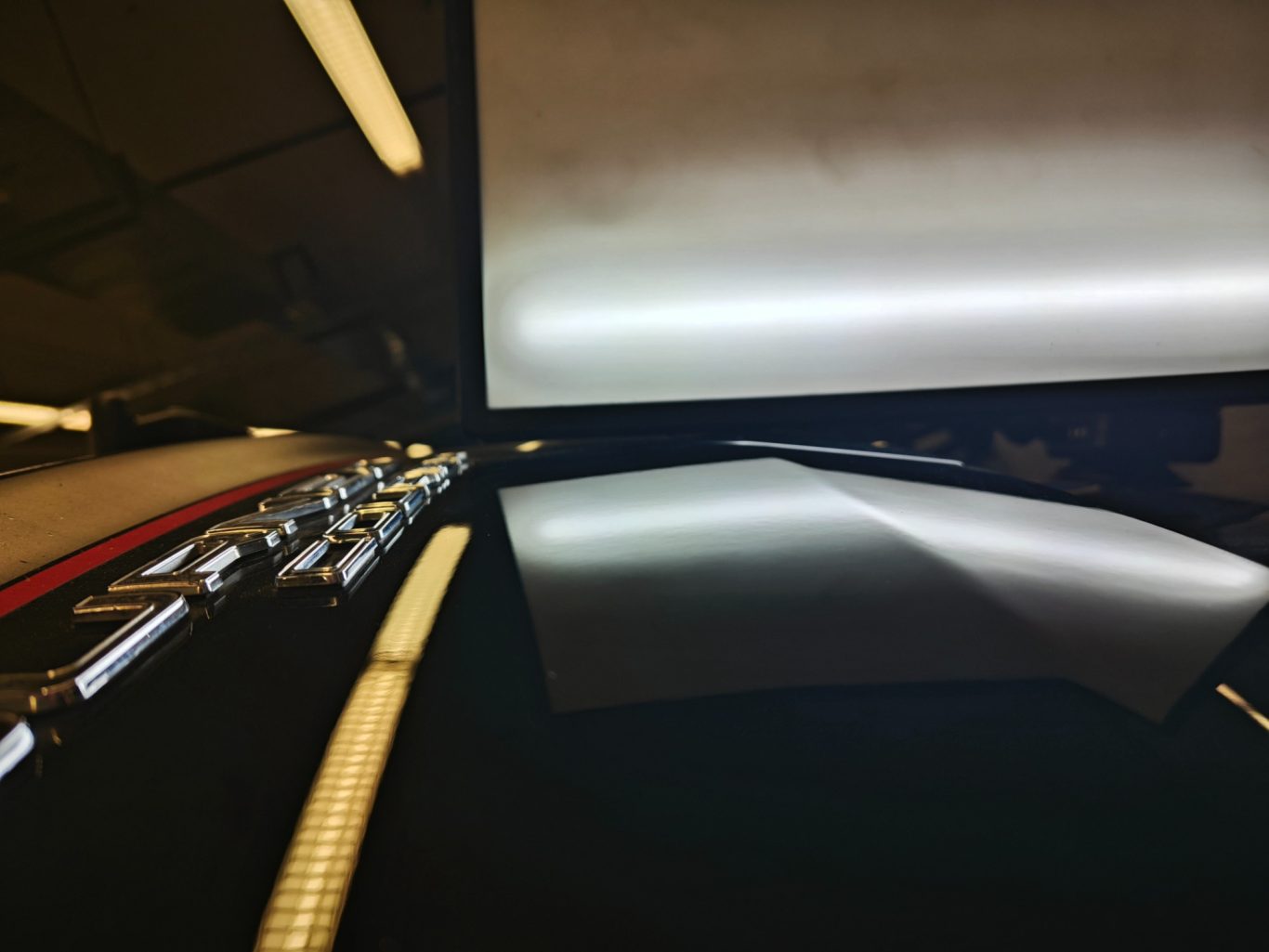 Ford Courier Heckklappe nachher Reflektierende Oberfläche mit einem Monitor und unscharfen Lichtzeugen.